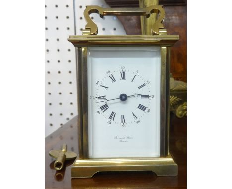 A modern brass cased carriage clock with platform escapement and key.