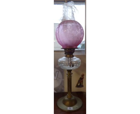 A traditional oil lamp with glass globe shade.