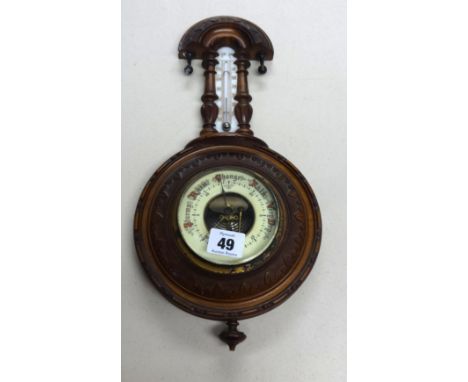 An early 20th century small carved walnut barometer.