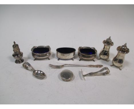 A collection of scrap silver to include three silver salt cellars, a baluster pepper, a spoon and pusher and a pickle fork  