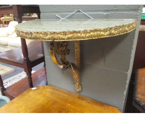 A gilt metal demi-lune marble topped wall bracket together with two giltwood wall brackets and a green painted wall bracket (