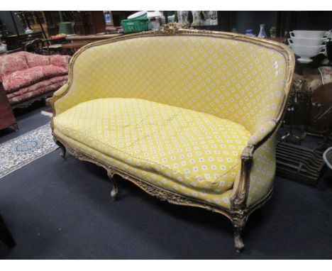 A Louis XV style giltwood three seater sofa, upholstered in a geometric yellow fabric, 214cm wide  