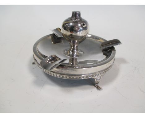 A silver ashtray with central perpetual light  