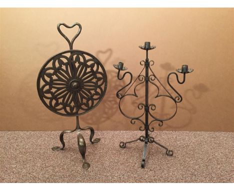 A small Art Nouveau iron firescreen, the rotating pierced circular screen to a columnar upright with heart-shaped handle and 