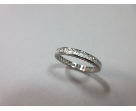 An 18ct white gold and white hardstone full hoop eternity ring, the step cut stones channel set to an 18ct shank with pattern