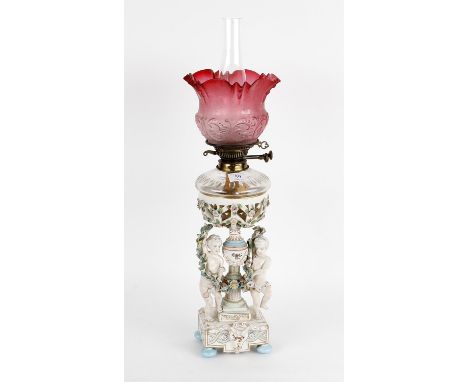 
	
		A late 19th century German porcelain oil lamp base, figural decoration, arrow marks, 35cms high; together with glass res