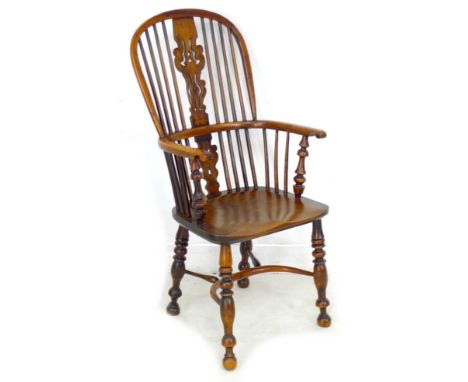 A Georgian yew and elm Windsor chair, high rounded back with stick supports centred by a pierced and shaped splat, turned leg