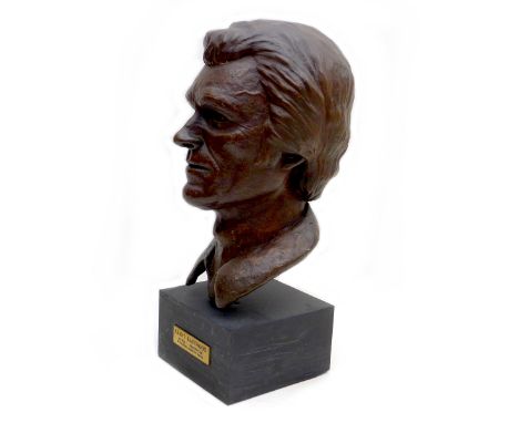 Doreen Kern (British, 1931-2021): Clint Eastwood resin bust, signed and dated '77', raised upon a wooden plinth, 24 by 8.5 by