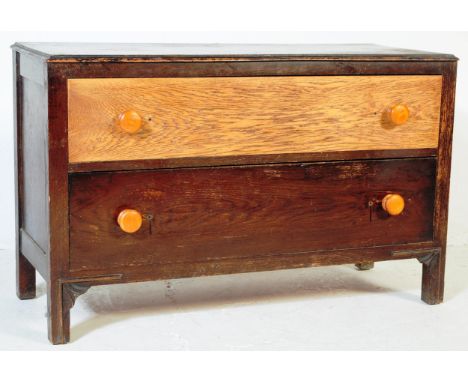 Early 20th century oak low two drawer - two tone end of bed chest of drawers. Raised on bracket feet with twin drawers having