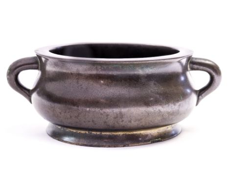 A Chinese bronze twin handled censer, low sided of bombe form with twin handles, recessed Xuande mark and possibly of the per