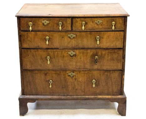 A Queen Anne period walnut chest of drawers, circa 1710, comprising two short and three long graduated drawers, retaining bra