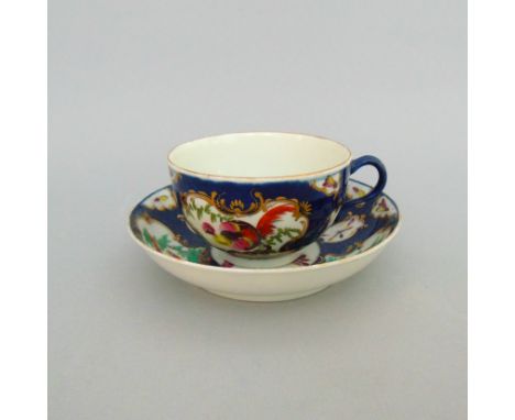 A Worcester tea cup and saucer, decorated with the ‘Fancy Birds’ pattern on a blue scale ground, circa  1765-70 , blue fret m