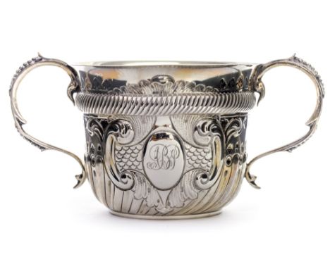 A George V silver twin handled cup, in the Charles I style, the lower section reeded and fluted below stamped acorn and flowe