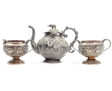 An Indian three piece white metal tea service with repousse deity figures and Elephant filial to teapot, 19th/early 20th Cent