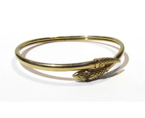 A 9ct gold snake bangle with emerald set eyes