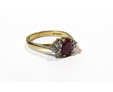 A ruby and diamond dress ring the central oval ruby flanked by three diamonds 