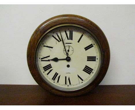 An early 20th Century Empire 8" dial clock with Roman numerals, oak cased with key 