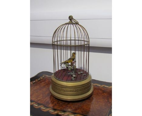 A late 19th Century early 20th Century automaton yellow singing bird with branch and foliage