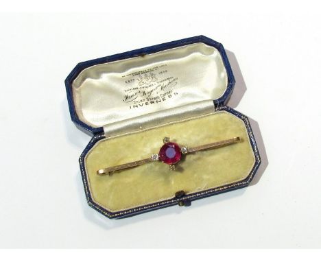 A gold diamond and synthetic ruby bar brooch, the large ruby set with four single diamonds in N E S W setting   