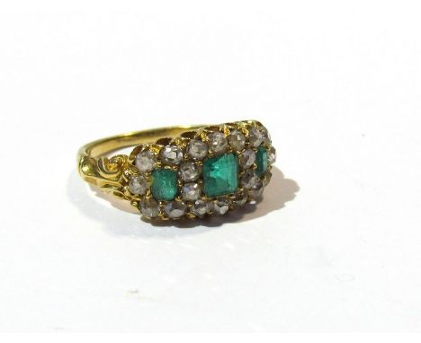 A gold emerald and diamond cluster ring, the three emeralds framed by diamonds, unmarked