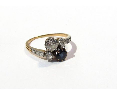 A sapphire and diamond crossover ring .50ct diamond and sapphire flanked by two .10ct diamonds, diamond set shoulder