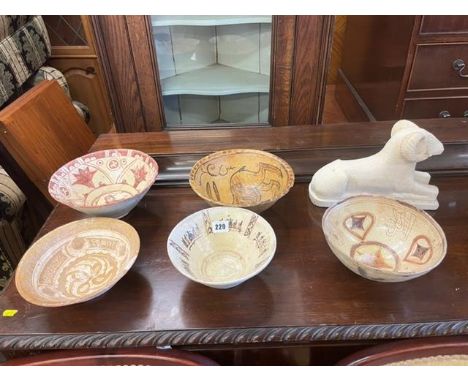 Five Islamic ceramic bowls and a Perisan lime stone figure, a.f