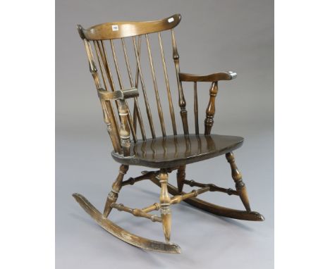 A comb-back rocking chair with a hard seat, &amp; on turned supports with turned stretchers. 