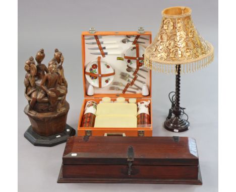 A Brexton picnic set with an orange fibre-covered case; a carved treen large figure group ornament; two table lamps; &amp; su