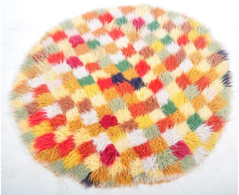A retro vintage 1960's woolen woven carpet rig having hand knitted dyed wool patchwork panels forming the larger overall piec