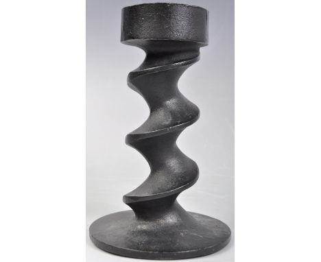 A heavy black finished cast iron candlestick by welsh design company ' Image Three Design Group '. The candle stick holder ha