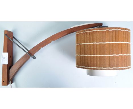 A retro vintage 20th Century Danish teak metamorphic wall light sconce lamp having a cylindrical wood panel shade with bow ad