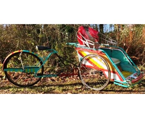 An impressive retro vintage front seated Thai Rickshaw bicycle bike pedal taxi having a teal painted tubular frame with twin 