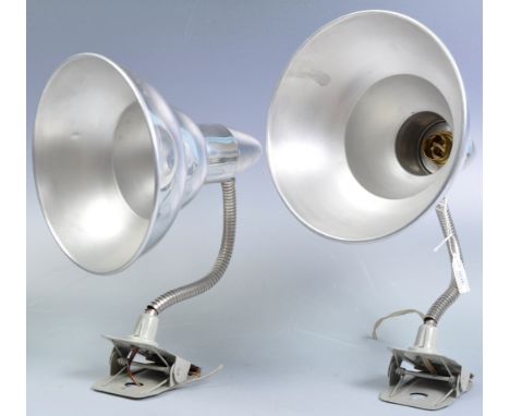 A pair of retro vintage 20th century chrome polished work lamps / desk lights having graduating conical shades raised on adju