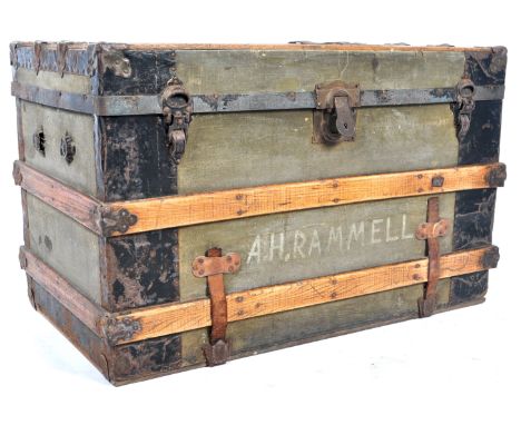 An antique early 20th Century oak and iron bound travel trunk / coffee table of simple rectangular form having a green canvas