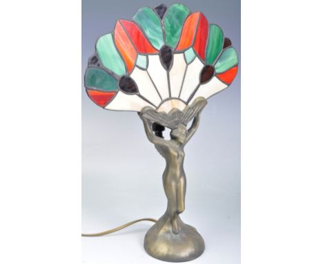 An Art Deco style table lamp with stained glass leaded fan panel. The painted metal figure in the form of a nude female suppo