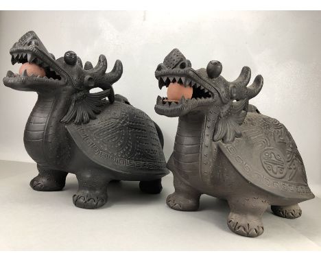 Pair of black painted pottery Chinese dragons with ceramic balls in mouths and turtle handled lids on their backs, stamped to