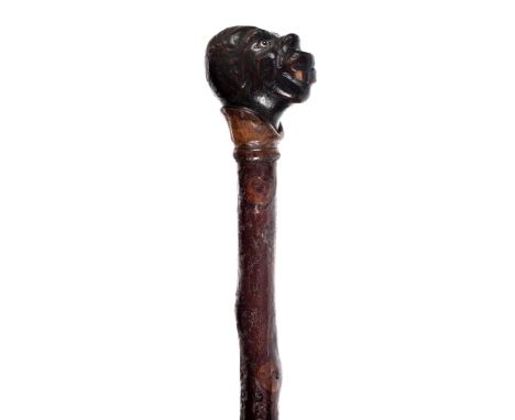 *Walking Cane. A 19th century Folk Art Anti-Slavery walking stick,  the handle carved with an African head inset with glass e