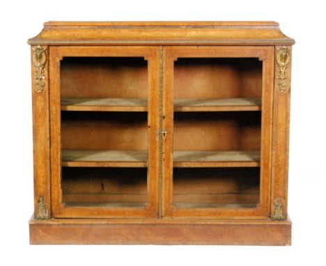 A 19th Century figured walnut credenza with gilt metal mounts, enclosed by a pair of line inlaid and banded glazed doors belo