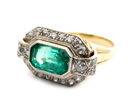 An 18ct emerald and diamond plaque head ring, the central emerald cut emerald weighing approximately 4.8cts, collar set withi