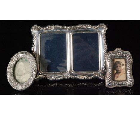 A modern hallmarked silver double easel photograph frame with C scroll and floral border decoration, Sheffield 1996 together 