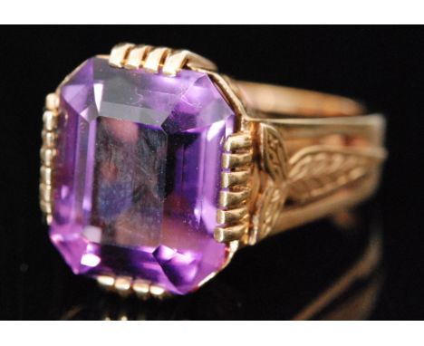 A 9ct hallmarked single stone amethyst ring, emerald cut claw set stone to feathered detailed shoulders, ring size K 1/2, Bir