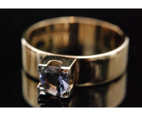 A 9ct hallmarked single stone iolite ring, claw set stone to a wide shank, ring size leading edge L. 