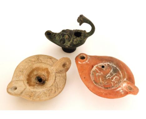 A Roman terracotta oil lamp decorated with an erotic scene and another with leaf border and a bronze Bacchus example (3)