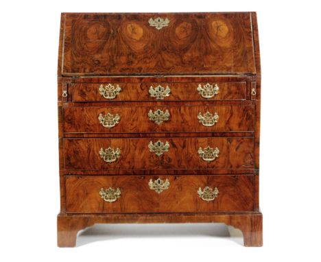 An 18th Century walnut oyster veneered fall front bureau, the fitted interior above four graduated long drawers and bracket f