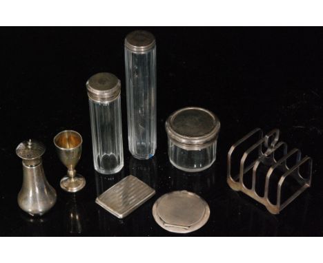 Three various hallmarked silver topped toilet jars, a 1930s circular engine turned powder compact, a vesta case, toast rack, 