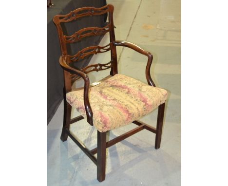 A  mahogany elbow chair with pierced ladder back and an overstuffed seat, with H-form stretcher frame, some later repairs, S/