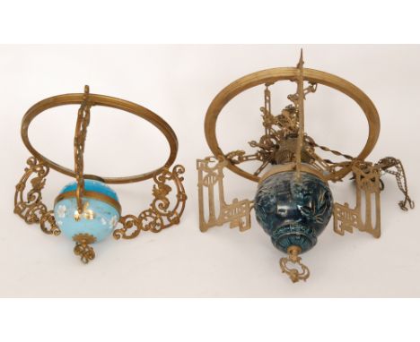 An early 20th Century pressed gilt metal ceiling light fitting with blue reservoir and applied decoration with white opaque s