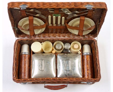 Coracle wicker picnic basket with contents including 2 flasks, cups, cutlery, plates, etc., W.57cm. (a lot)All 4 forks and 4 