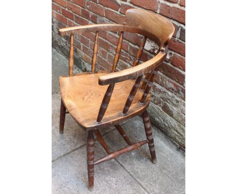 An early 20th C ash and elm captain's chair with ring-turned spindled back and supports