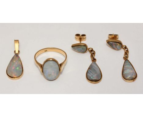 A four-piece 18ct gold jewellery set comprising a ring, a pendant and a pair of drop earrings, all set with opals. Gross weig